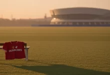 Manchester United jersey on training pitch with Barcelona stadium in distance at sunset