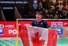 Victor Lai celebrates with a Canadian flag after defeating Jonatan Christie to win the Indonesia Open badminton men’s singles title in Jakarta. (Photo: AFP)