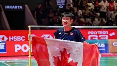 Victor Lai celebrates with a Canadian flag after defeating Jonatan Christie to win the Indonesia Open badminton men’s singles title in Jakarta. (Photo: AFP)